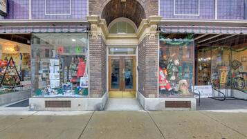 A storefront with a brick facade, large display windows, and a sign indicating it sells antiques and collectibles.