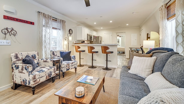 A spacious living room with a sofa, two armchairs, a coffee table, and a kitchen in the background. - Near Trails & Vast Access! Modern Burke Home Base (East Burke)