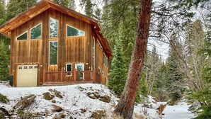 A wooden cabin with large windows, a deck, and a snowy landscape. - Scenic Creekside Retreat! Rocky Mountain Cabin (Dumont)