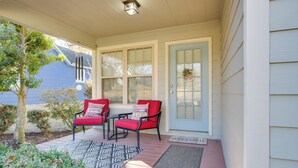 A porch with two red chairs, a small table, and a blue door with a 'welcome' sign. - 2 Mi to Pickwick Landing State Park: Home w/ Yard (Counce)