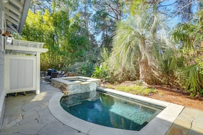 A pool with a stone deck, surrounded by lush greenery and a pergola. - Luxe 30A Group Getaway! Home w/ Pool & Patio (Santa Rosa Beach)