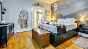 A bedroom with a bed, bedside lamps, a dresser, a nightstand, and a dreamcatcher on the wall. - 'storybook Craftsman' Home w/ Private Hot Tub! (Mount Airy)