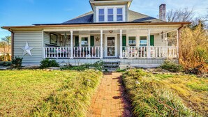 A two-story house with a porch, a star decoration, and a chimney. - 'storybook Craftsman' Home w/ Private Hot Tub! (Mount Airy)