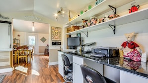A kitchen with a dining area, wooden flooring, and a TV. - 'storybook Craftsman' Home w/ Private Hot Tub! (Mount Airy)