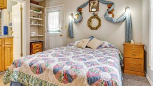 Una camera da letto con un letto, una cassettiera, un armadio e una scaffalatura.