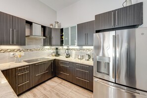 A modern kitchen with dark wood cabinets, stainless steel appliances, and a tiled backsplash. - 3 Mi to Historic Dtwn Hartland: Family Retreat (Hartland)