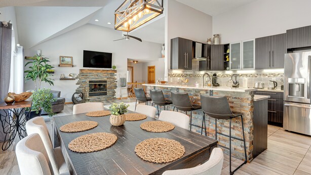 Una cucina moderna con isola centrale, elettrodomestici integrati e zona pranzo con un tavolo e sedie grandi.