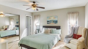 A bedroom with a bed, a chair, a ceiling fan, and a painting on the wall. - Stay & 'sea' Port Charlotte: Family Home w/ Yard (Port Charlotte)
