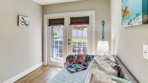 A bedroom with a bed, a window, a door, and a wall-mounted lamp. - Stay & 'sea' Port Charlotte: Family Home w/ Yard (Port Charlotte)