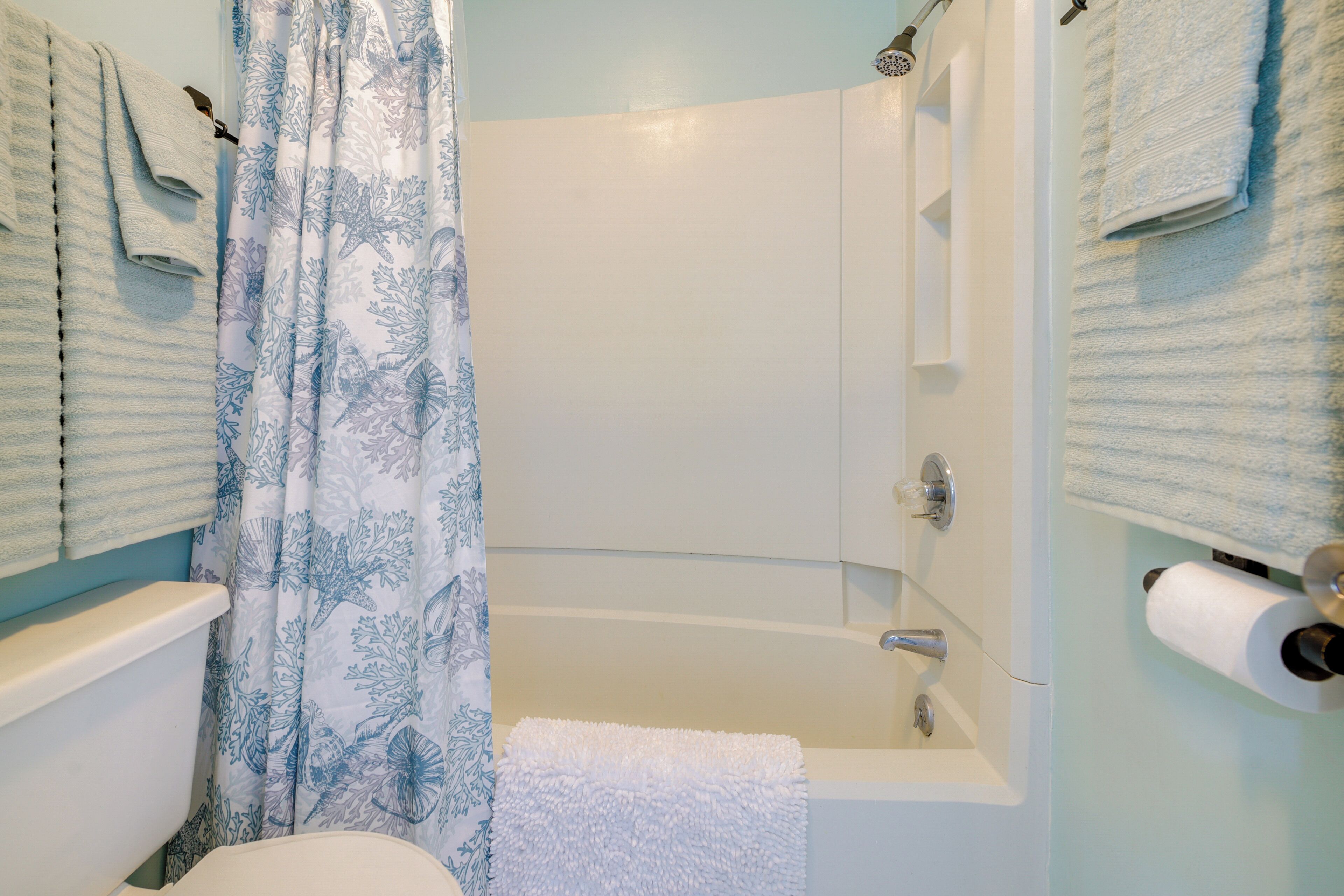 Une salle de bain avec une baignoire, des toilettes et un rideau de douche.