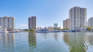 Un puerto deportivo con varios yates amarrados, rodeado de edificios altos.