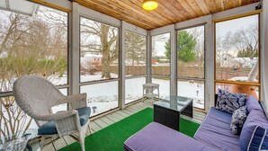 A covered patio with a wicker chair, a purple sofa, and a glass table. - 2 Mi to Main Street! Cozy Burlington Guest Suite (Burlington)