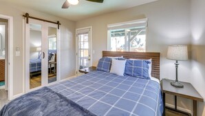 Un dormitorio con cama, mesita de noche, lámpara y ventilador de techo.