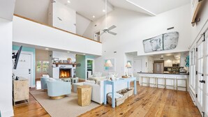 Ein geräumiger Wohnbereich mit Kamin, hellblauen Sofas und Holzboden.