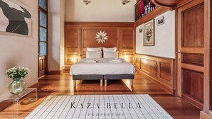 Ein geräumiges Schlafzimmer mit einem großen Bett, Holzwänden und einem dekorativen Stern an der Wand.
