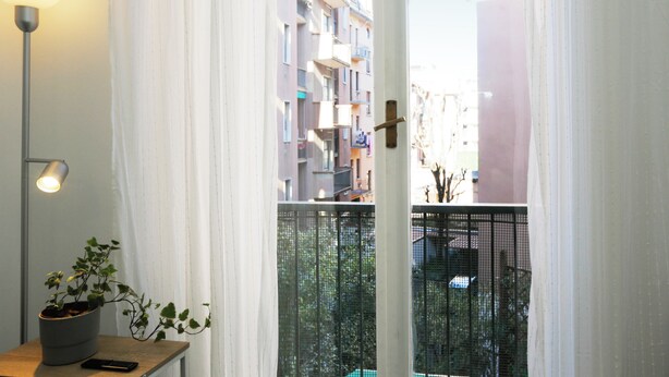 A view from a balcony with a potted plant and a lamp on a table. - Centro-Brera, MM2 Moscova-Garibaldi, Corso Como. (Milano)