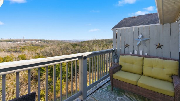 A balcony with a wicker sofa and decorative wall elements. - Ozark Viewpoint Retreat for 8 (Branson)