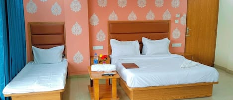 A double room with two single beds, a wooden nightstand, a small table with a remote control, and a door with a sign.