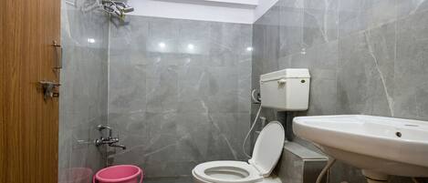 A bathroom with a toilet, sink, and shower.