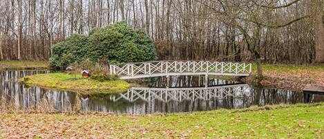 A bridge over a calm body of water with a forest in the background.