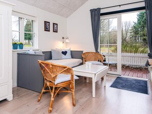 Une pièce confortable avec un lit, un canapé, une table à manger et un fauteuil en osier.