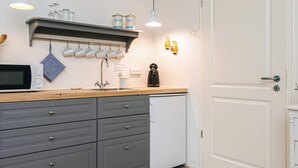 A compact kitchen with a microwave, sink, and coffee maker. - 5 Star Holiday Home in Ansager (Ansager)