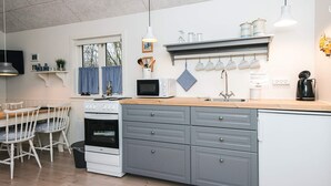 A modern kitchen with white cabinetry, a wooden countertop, and a built-in oven. - 5 Star Holiday Home in Ansager (Ansager)
