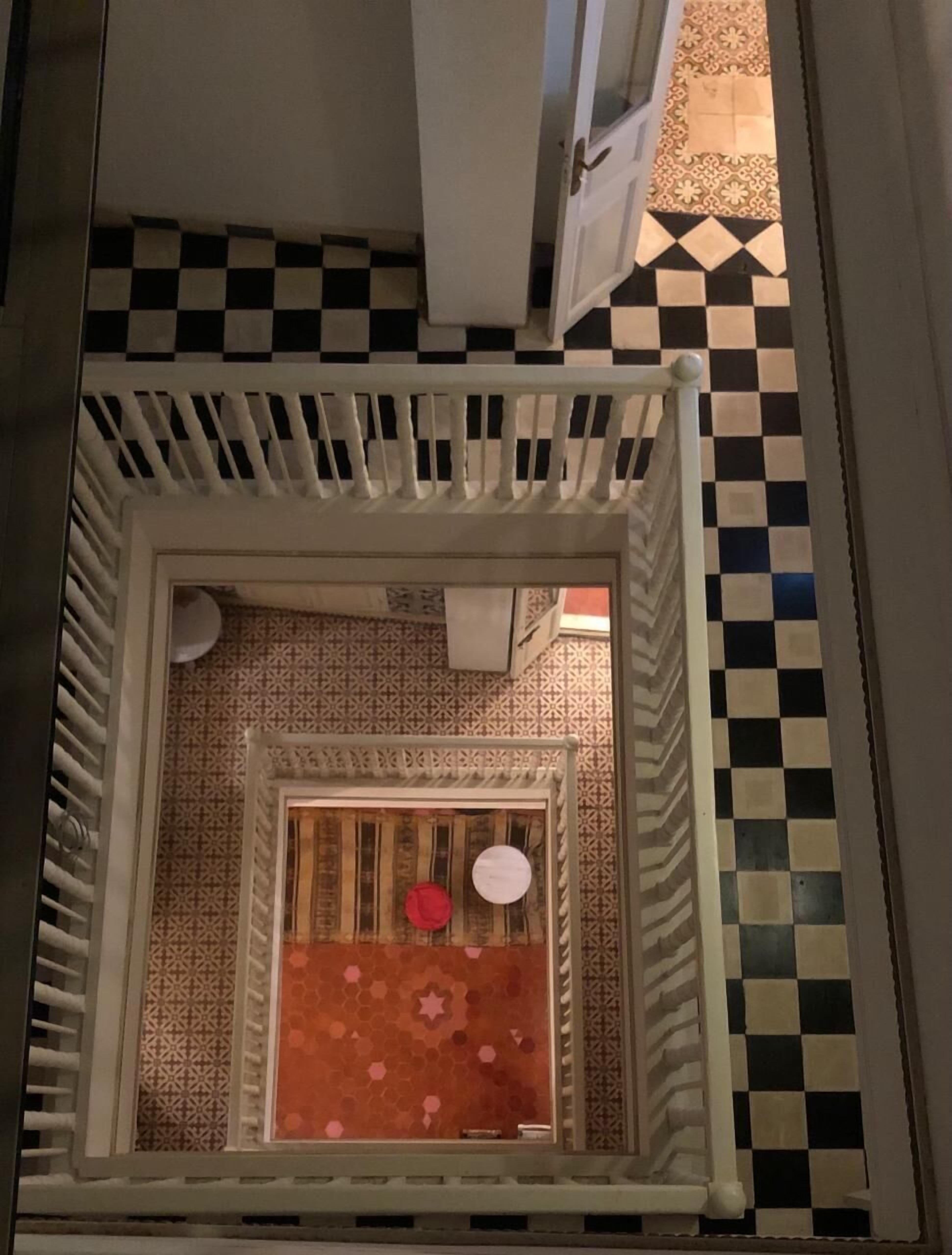 A small, enclosed space with patterned walls and a checkered floor.