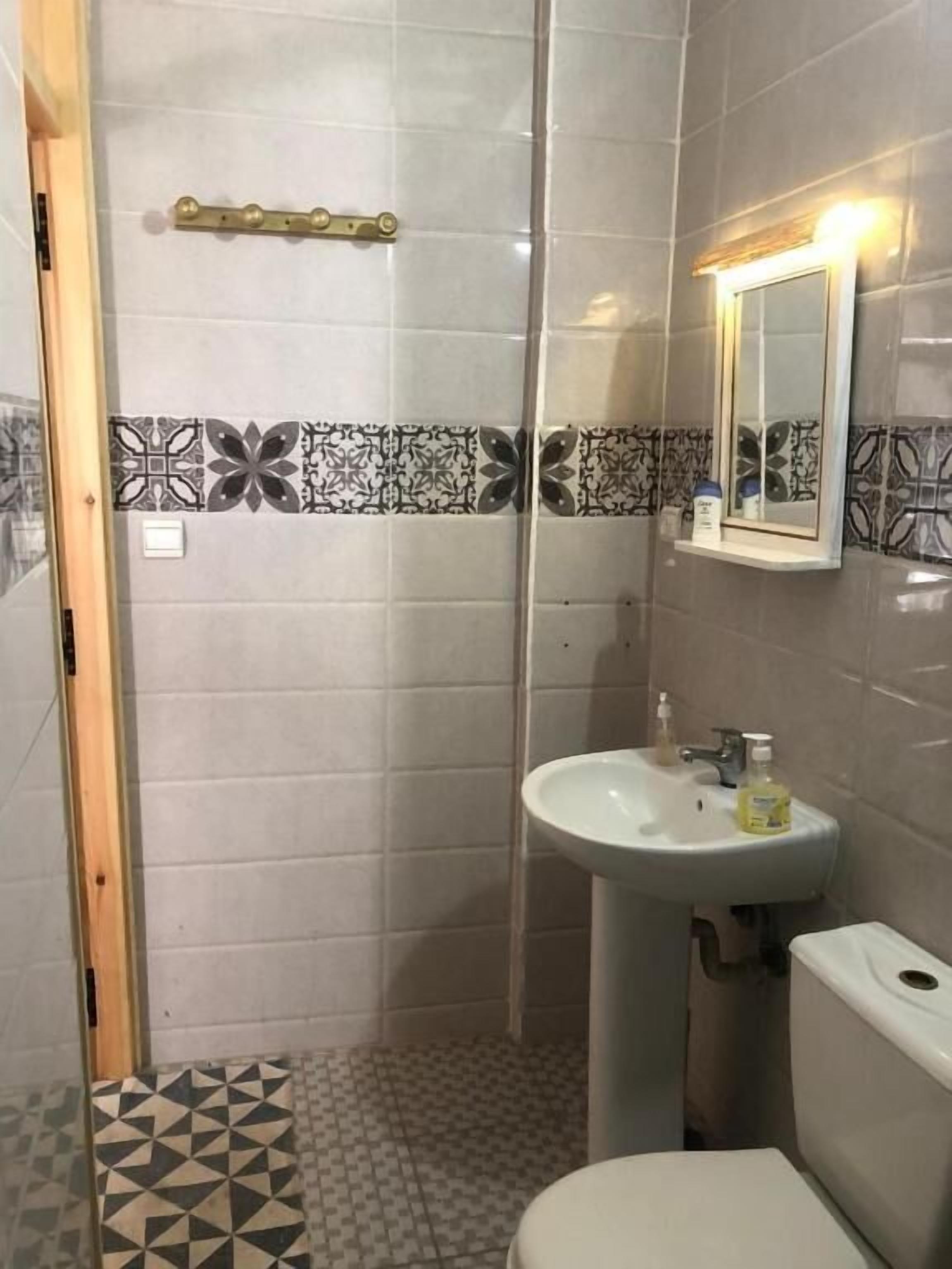A bathroom with a shower, a sink, and a toilet.