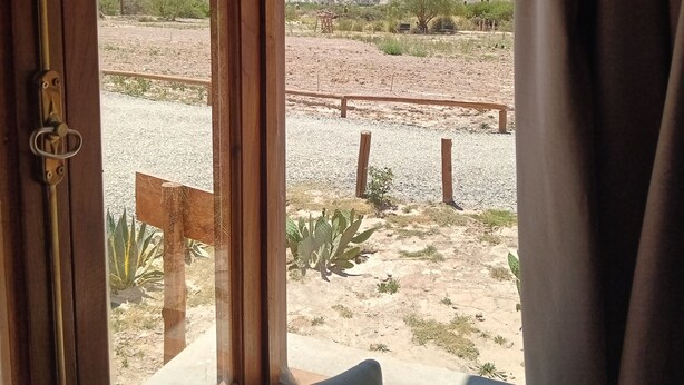 Una habitación con vista a un paisaje desértico a través de una ventana.