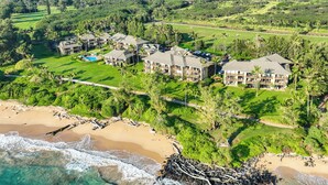 Vue aérienne d’un complexe hôtelier comprenant plusieurs bâtiments, un terrain de golf et une plage.
