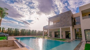 A modern two-story house with a swimming pool, a car, and a well-maintained lawn. - Villa Lumeria (Marrakech)