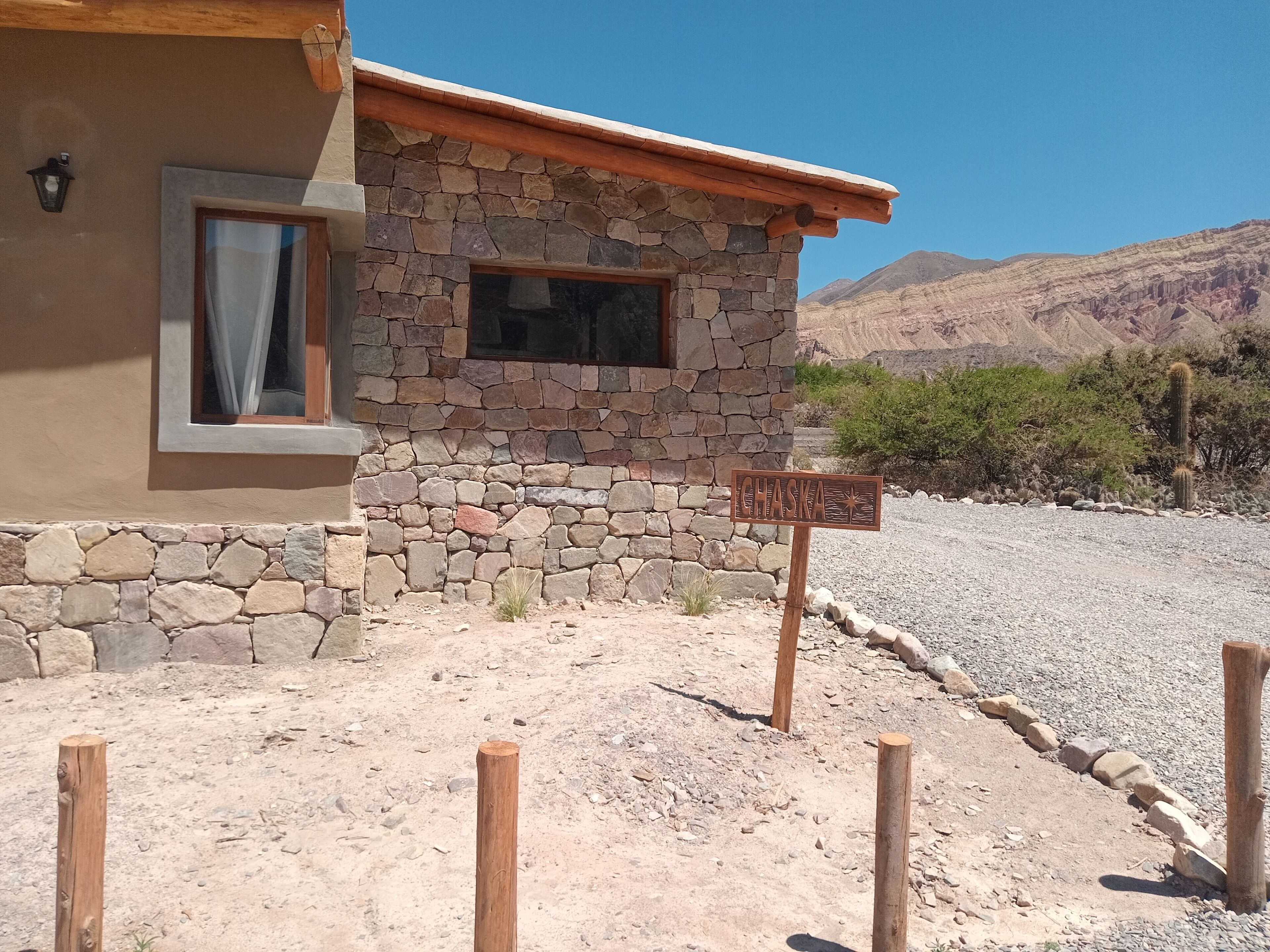 A rustic stone building with a wooden sign reading "Chaska."
