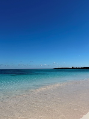 Una spiaggia con acqua cristallina color turchese e una battigia sabbiosa.