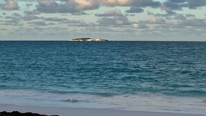A beach with a view of the ocean and a distant island.