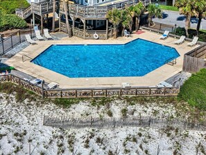 A rectangular pool with a wooden deck and lounge chairs, surrounded by a sandy beach area. - Fall 2026 Rate Drop! 2br/2ba Dog Friendly! Book Changes in Attitude today! (Port St. Joe)