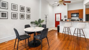 Una cocina moderna con armarios de madera, un refrigerador negro y una encimera blanca.