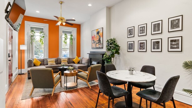 Una sala de estar moderna con un sofá, sillas, una mesa de comedor y una chimenea.
