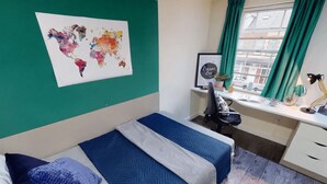 A room with a bed, a desk, and a world map on the wall. - Ty Willis House (Bangor)