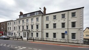 A multi-story hotel with a classic architectural style, featuring a prominent entrance with a canopy and a signboard. - Ty Willis House (Bangor)