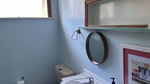 Ein kleines Badezimmer mit Toilette, Waschbecken und Spiegel.