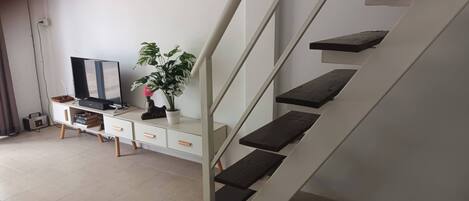 A staircase with wooden steps and a white wall.