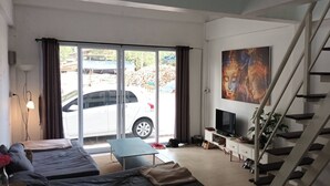 Ein modernes Wohnzimmer mit einer Couch, einem Fernseher und einer Treppe.