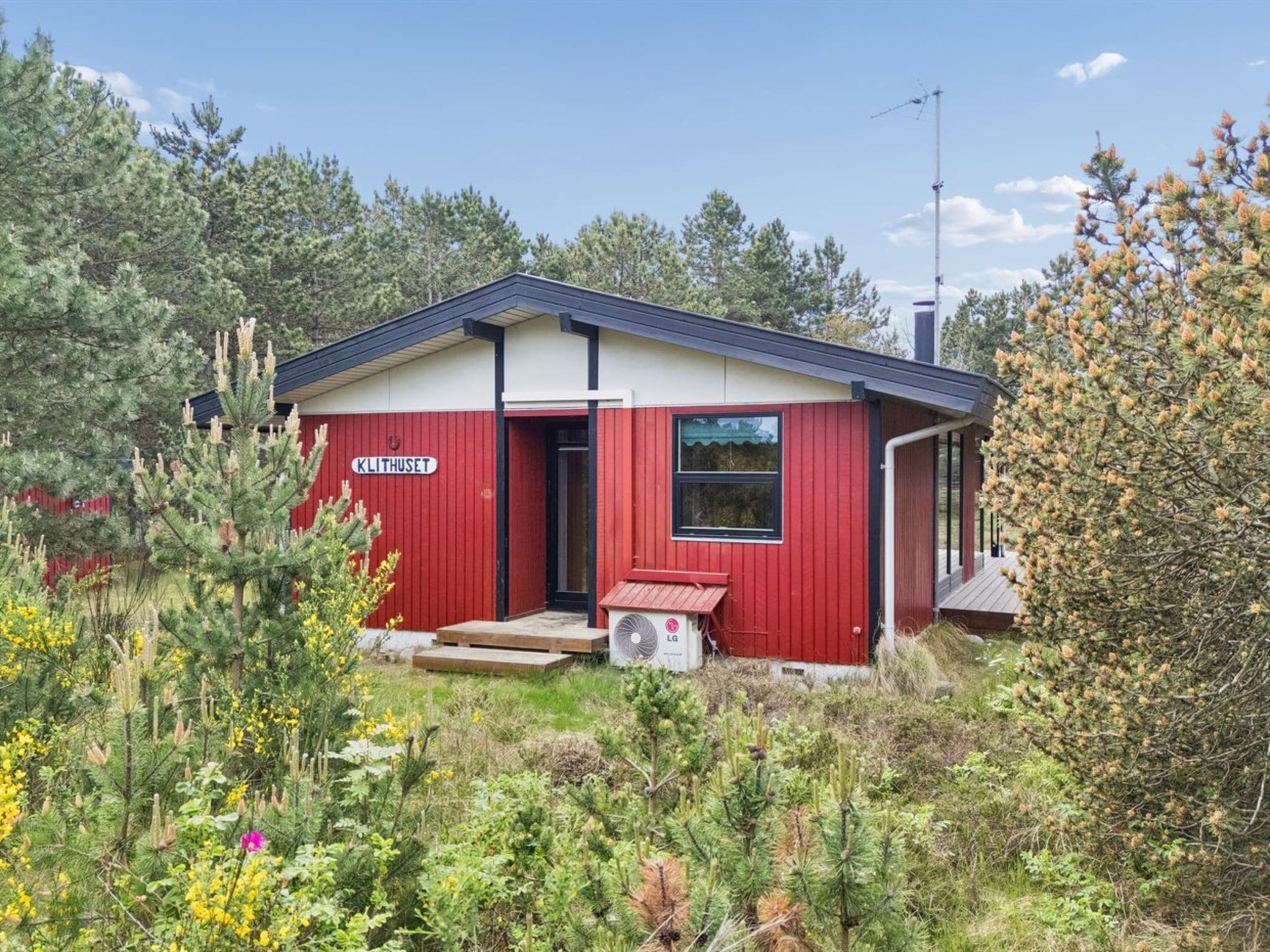 Een rood gebouw met een bord waarop 'KLITHUSET' staat en een klein portaal.