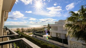 Varanda com vista para uma praia e um edifício moderno.