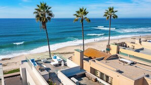 A beach view with palm trees, a pool area, and a rooftop terrace. - Featured on HGTV "Christina On The Coast" - Stunning Ocean Views, Spa! (San Diego)