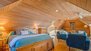 Una camera da letto accogliente con travi in legno, un letto grande, una scrivania e una poltrona.