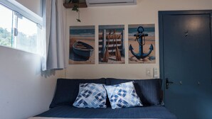 Une chambre à coucher avec un lit, deux oreillers, une fenêtre et trois tableaux accrochés au mur.