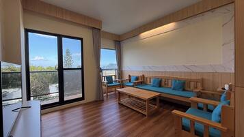 Luxury Quadruple Room, Ocean View | Living area | 55-inch flat-screen TV with digital channels