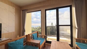 Exclusive Quadruple Room, Ocean View | Living area | 55-inch flat-screen TV with digital channels